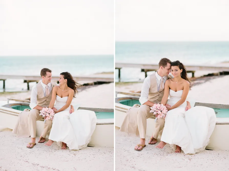 A serene beach with clear skies and a palm tree leaning over the shore.